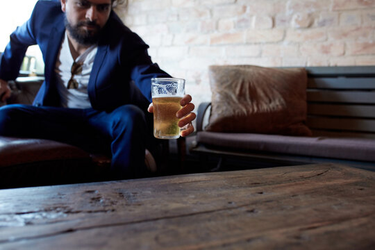 Hipster man enjoying drinking a beer at pub