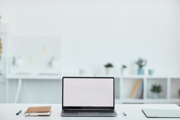 Minimal background image of open laptop with blank white screen at workplace in office, copy space