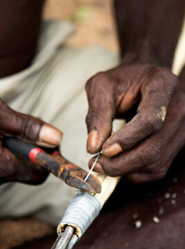 Close up of indigenous persons hands working with tools