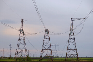 Electricity transmission power lines at sunset. High voltage tower with power lines