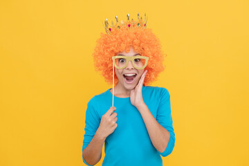happy childhood. girls birthday party. happy funny kid in curly wig and crown.