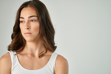 brunette with a serious expression in a white t-shirt dissatisfaction close-up