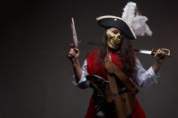 Tattooed female pirate posing with cutlass and gun