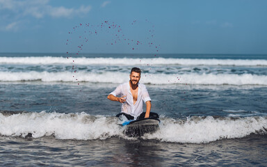 Young guy with wine on surfboard