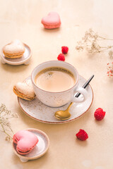Fototapeta na wymiar Cup of coffee with sweet macarons on kitchen table