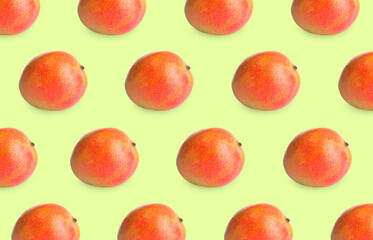 Delicious ripe mangoes on light green background