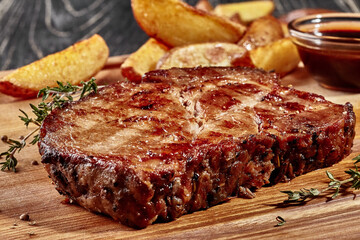 Fried pork steak with potato wedges and barbecue sauce