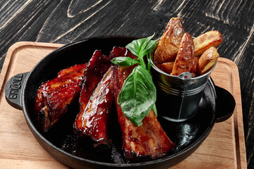 Roasted pork ribs in barbecue sauce with country style potatoes