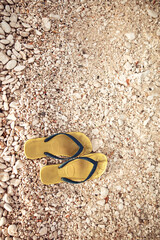 Fototapeta na wymiar Flip-flops on a rocky ocean beach.