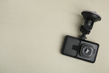 Modern car dashboard camera with suction mount on light background, top view. Space for text - obrazy, fototapety, plakaty