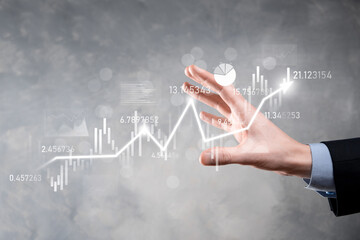 Naklejka premium Businessman in hand hold banking business finance graph and invest in stock market investment point,economic growth and investor concept.analysis virtual stock market chart,analyze by use technology