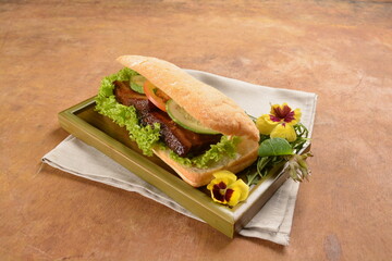 cook kong bak bao asian braised pork belly with vegetables in long focaccia bread and flower salad on wood table asian traditional pastry sandwich menu