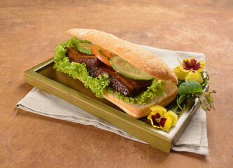 cook kong bak bao asian braised pork belly with vegetables in long focaccia bread and flower salad on wood table asian traditional pastry sandwich menu