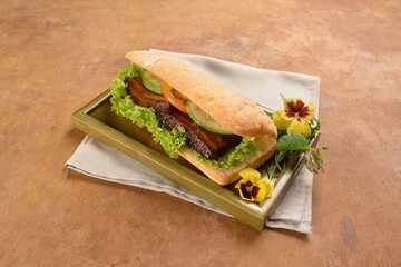 cook kong bak bao asian braised pork belly with vegetables in long focaccia bread and flower salad on wood table asian traditional pastry sandwich menu