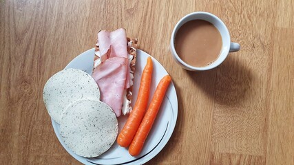 Breakfast plate with vegetables, carrots, crispbread, cheese and coffee