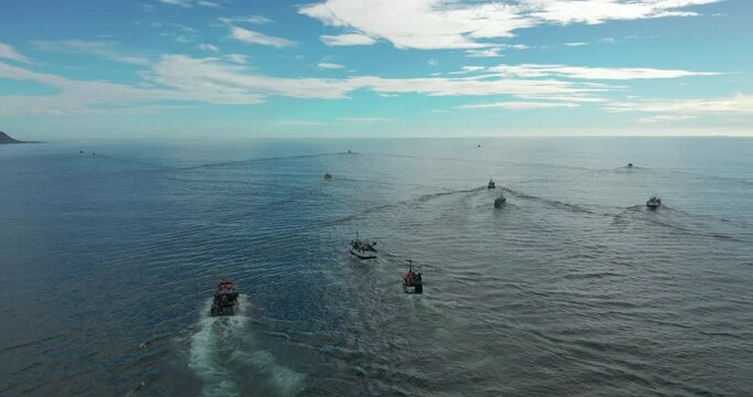 Aerial view. Fishing boats trawler ship sailing on ocean on sunset.