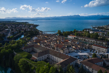 Naklejka na ściany i meble Aerial panorama of the city of Peschiera del Garda on Lake Garda, Italy. The city of peschiera del garda at sunset. Aerial view of a tourist town in Italy. Italian resorts on Lake Garda.