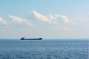 Dry cargo ship on the river, the sea in the distance on the horizon. Ship on the water against the...