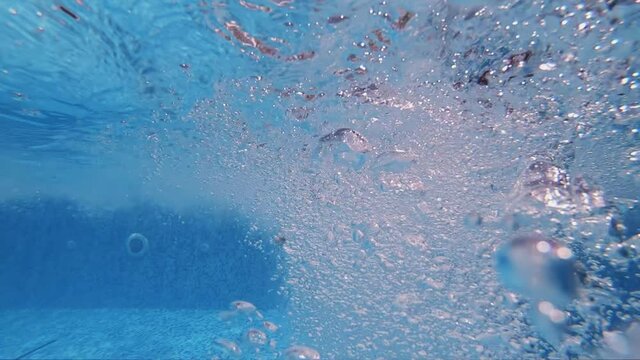 Raising underwater bubbles in thermal swimming pool, slow motion