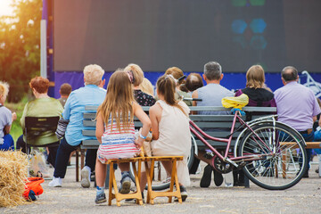 Open-air cinema. People watching a movie on a summer cinema screen