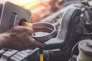 Hand mechanic in repairing car,Change the oil, Refueling and pouring oil quality into the engine...