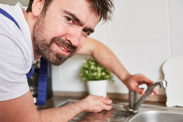Installateur beim Anschließen von Küchenarmatur