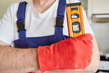 Handwerker mit Wasserwaage und Handschuhen