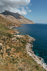 Fototapeta na wymiar Beach vacation in Italy, Sicily, turquoise water,sandy beaches,hiking trails.Holiday paradise travel scenery.Scenic coastline of Zingaro Nature Reserve with rocks.Beautiful lagoons with clear water.