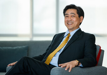50s Asian senior executive businessman entrepreneur wearing formal suit with luxury necktie, smart...