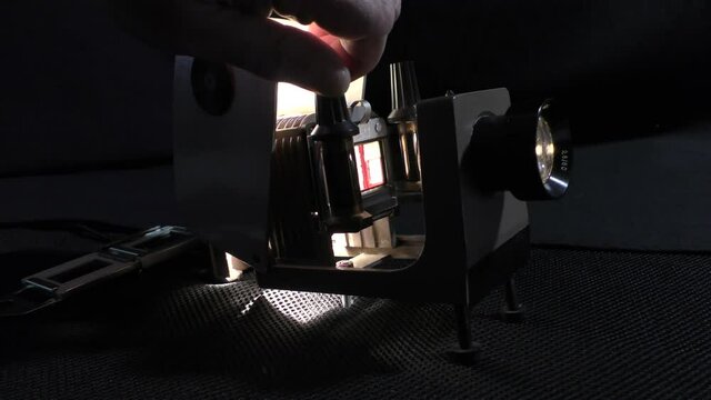 Old stylish 70s slide projector,
A man shows photographs from the family archive on a vintage filmoscope.