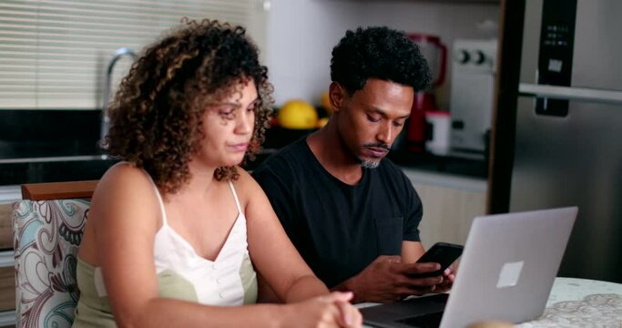 Couple concerned about money, black couple in front of computer at kitchen table
