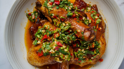 Thai Oyster chicken grilled with spicy sauce, cilantro, lime juice, red and green chillis.