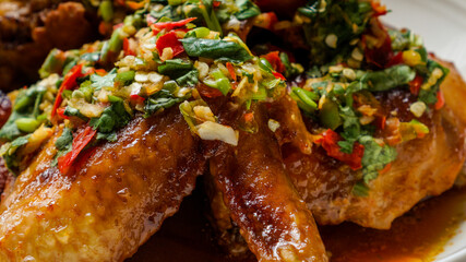 Thai Oyster chicken grilled with spicy sauce, cilantro, lime juice, red and green chillis.