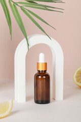 dark amber glass bottle with arch, lemon and palm leaf on beige background. copy space. Beauty concept, minimalism brand packaging mock up.