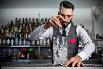 Bartender mixing cocktail in glass