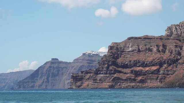 Blue Star Ferry sail along Santorini island in Greece. View of Fira, Imerovigli with Scaros rock