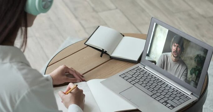 Young woman studying online using laptop and video call with teacher and learning