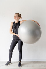 Fototapeta premium Portrait of a young fit woman holding fitball