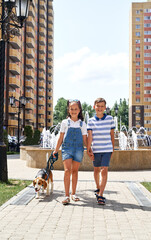 a little girl and a boy are walking with a dog . summer. heat. holidays