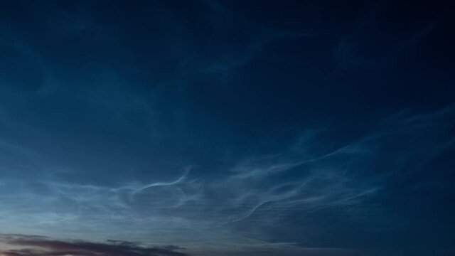 Beautiful time lapse of silvery (noctilucent, polar mesospheric) clouds glowing and shining at summer evening, calm and tranquil scenic view, wide angle shot