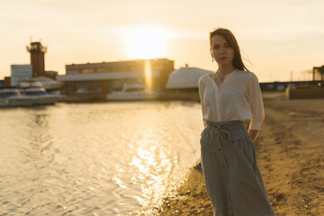 Woman in dress enjoys the sea shore.