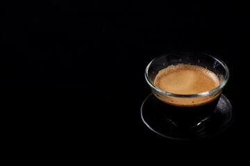 Coffee in glass cup on black background. Close up. Copy space. 