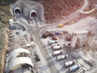 Concrete mixer trucks, concrete batching plant and construction materials at motorway tunnel...