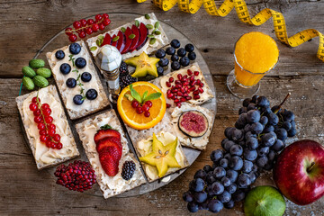Snack with crisp bread, fresh fruits and cheese on the wooden table.