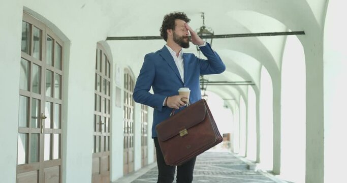 upset smart casual fashion model with coffee and suitcase, reacting, throwing coffee and getting on knees, negatively reacting to god against city background