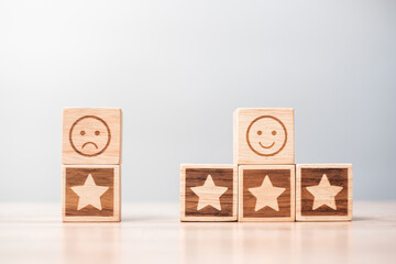 emotion face and Star symbol blocks on table background. Service rating, ranking, customer review, satisfaction, evaluation and feedback concept