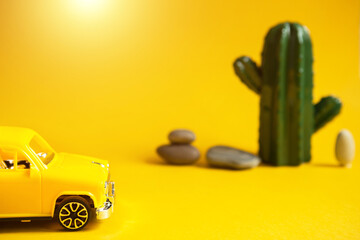 Summer trip by car-a yellow car on a background with a cactus-a tour to the desert, to the sea....