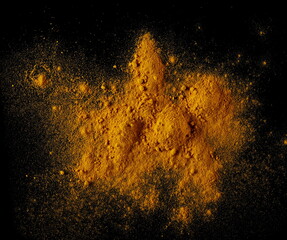 Turmeric (Curcuma) powder pile isolated on black background, top view