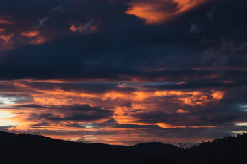sunset sky with pink and orange clouds over the mountains