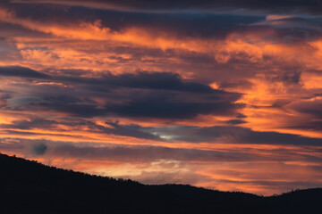 sunset sky with pink and orange clouds over the mountains